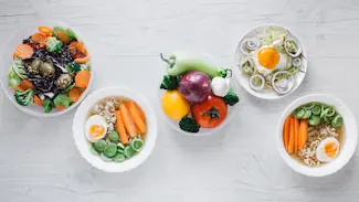 Bols colorés garnis de légumes, œufs et légumineuses, illustrant l'alimentation adaptée aux carences nutritionnelles