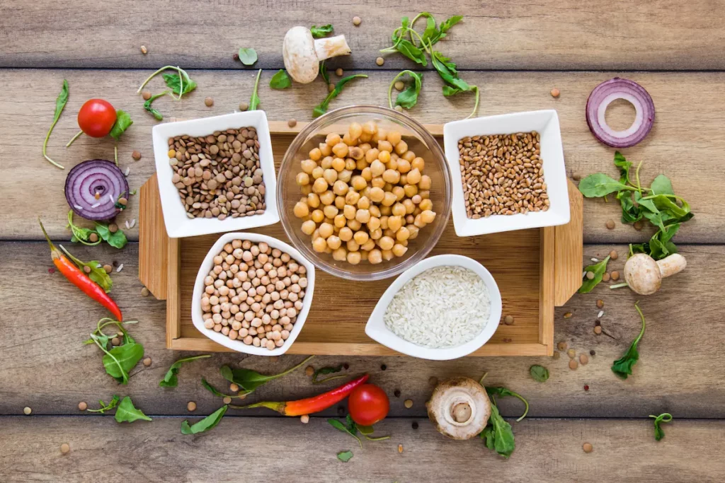 Bols de pois chiches, lentilles, céréales et légumes frais sur une table en bois, aliments à index glycémique bas