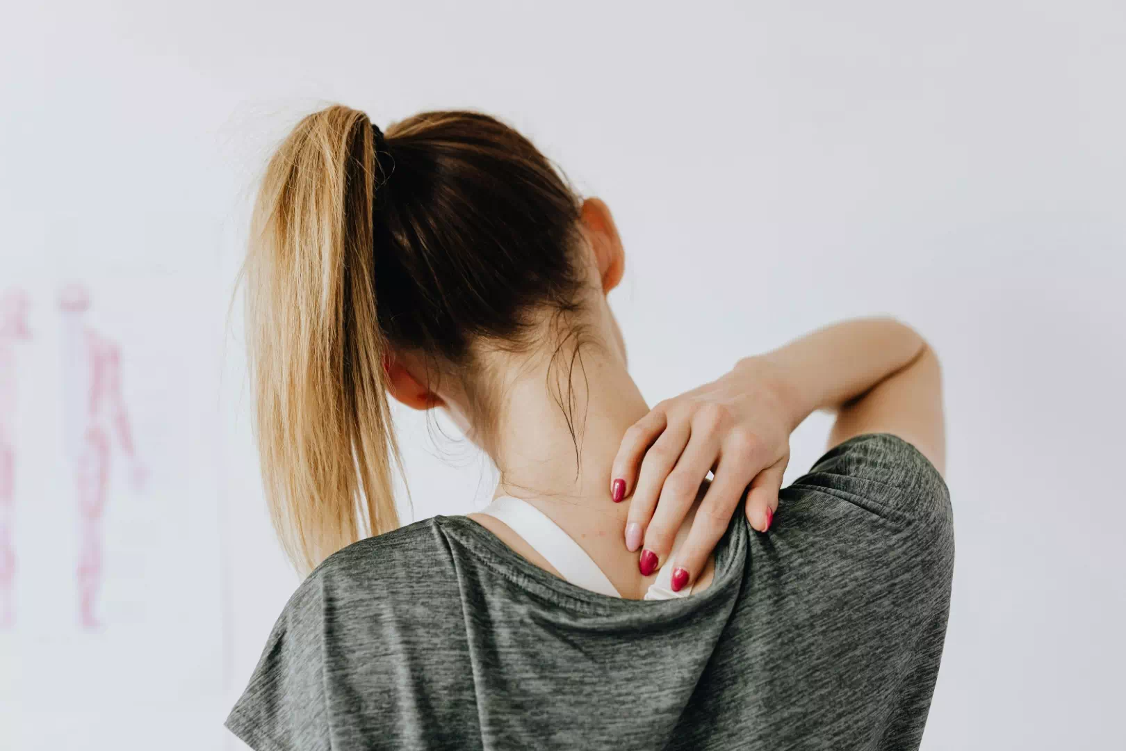 Femme active souffrant de douleurs aux cervicales et trapèzes, symptômes fréquents de la fibromyalgie
