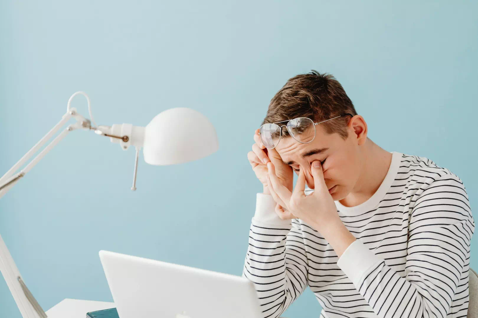 Homme fatigué devant son ordinateur portable illustrant les troubles du sommeil liés aux écrans.