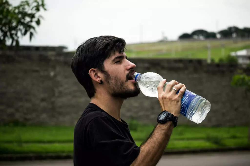 Homme buvant de l'eau pour soutenir la détoxification et le nettoyage du foie naturellement.