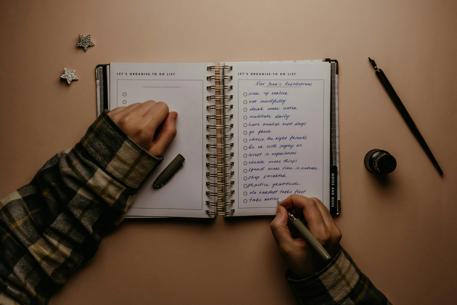 Personne rédigeant sa liste de bonnes résolutions de la nouvelle année dans un carnet pour atteindre ses objectifs santé