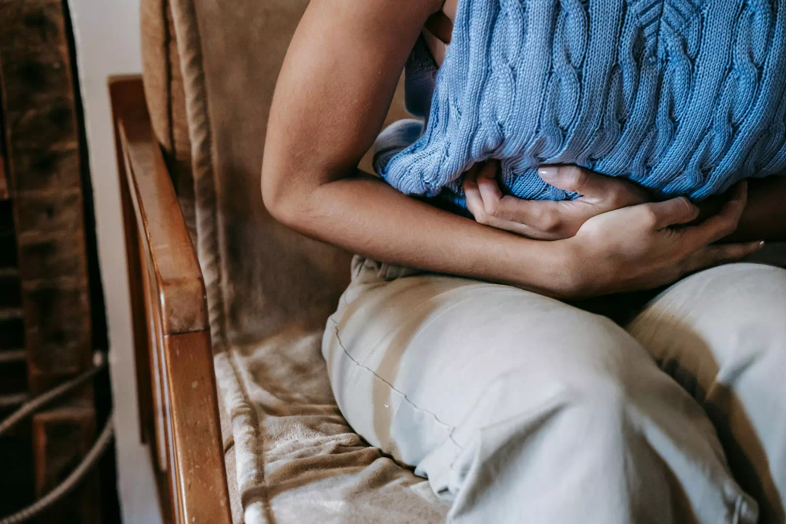 Femme souffrant de lourdeur digestive et de maux d'estomac, signes d'un foie engorgé en hiver.