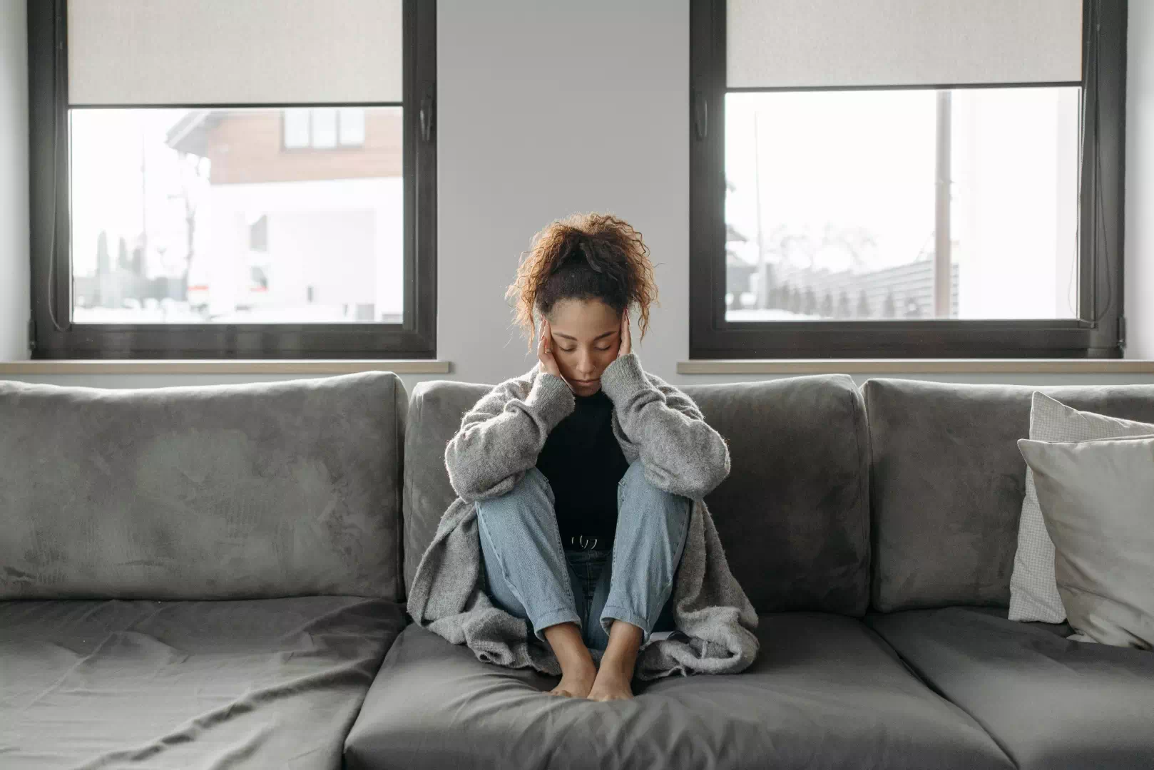 Femme épuisée sur un canapé illustrant la fatigue chronique et les symptômes du virus Epstein-Barr.