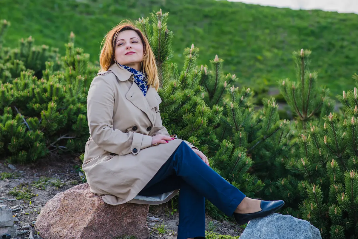 effet-menopause-corps-femme-serenite Femme élégante posant sereine dans un parc, illustration apaisée d'une transition de vie à l'âge de la ménopause