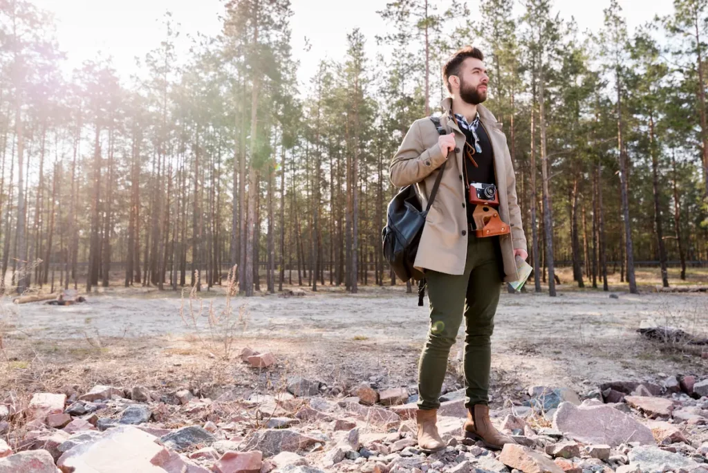 Homme randonneur en forêt, sac au dos, évoquant la marche et l'hygiène de vie pour mieux traverser cette transition